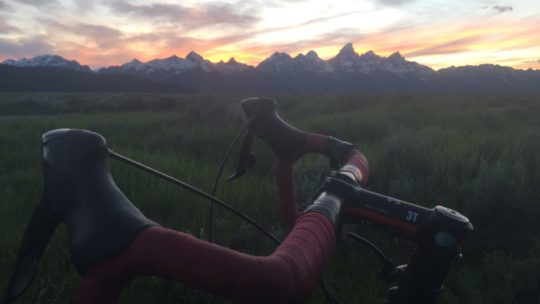 A Bicyclist Pauses In Front Of The Grand Teton Range During A Commute Home From Work