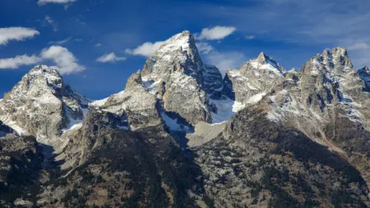 The Grand Teton Range Is An Impressive Skyline Against A Bright Blue Sky