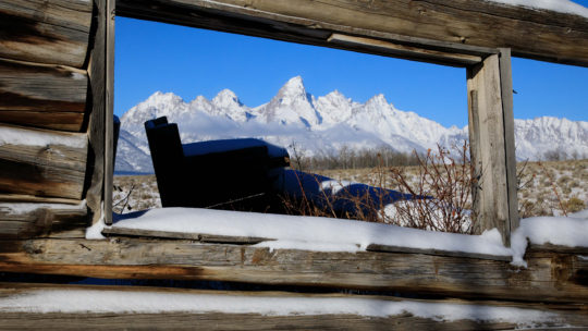 The Teton Range Is Visible Through The Window Of The Historic Shane Cabins In Jackson Hole