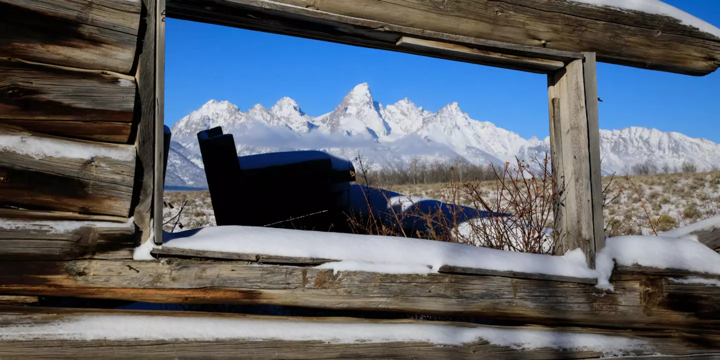 The Teton Range Is Visible Through The Window Of The Historic Shane Cabins In Jackson Hole