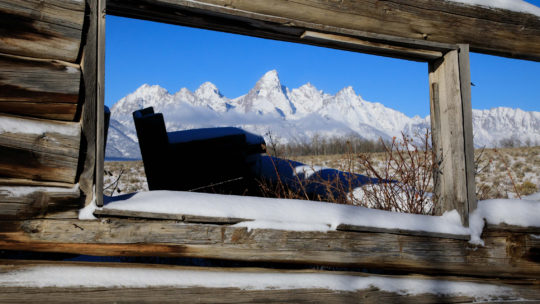 The Teton Range Is Visible Through The Window Of The Historic Shane Cabins In Jackson Hole