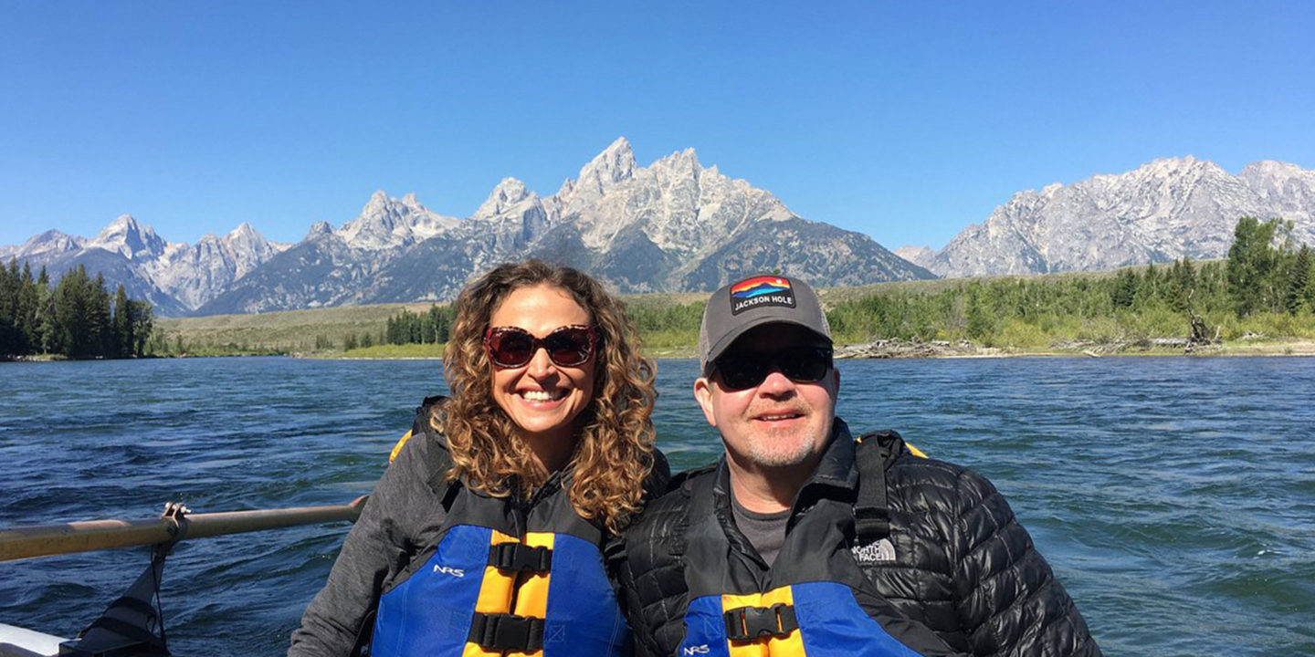 Two Guests Pose In Front Of The Grand Teton Range While Enjoying A Scenic Float Trip In Grand Teton National Park