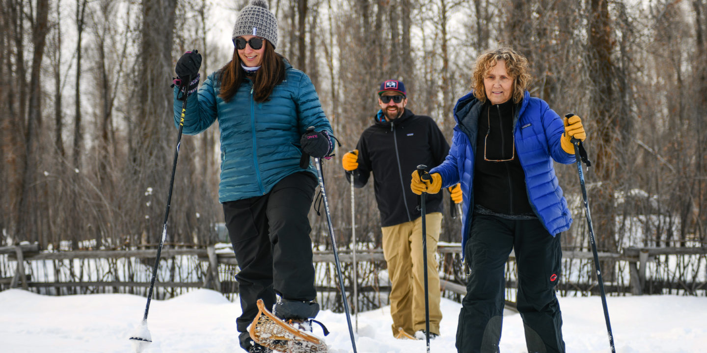 Three People Venture Out On Snowshoes On A Guided Tour With Jackson Hole Wildlife Safaris In A Cottonwood Clearing In Jackson Hole