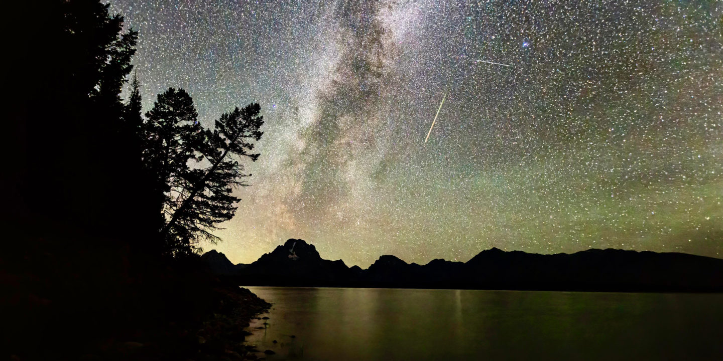 The Milky Way Is Highly Visible In The Night Sky Set Against The Backdrop Of The Teton Range With A Clear Silhouette Of Mount Moran In The Distance