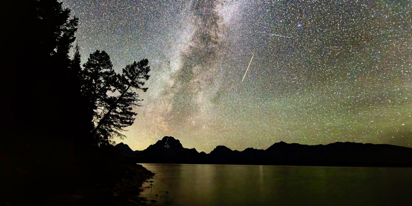 The Milky Way Is Highly Visible In The Night Sky Set Against The Backdrop Of The Teton Range With A Clear Silhouette Of Mount Moran In The Distance